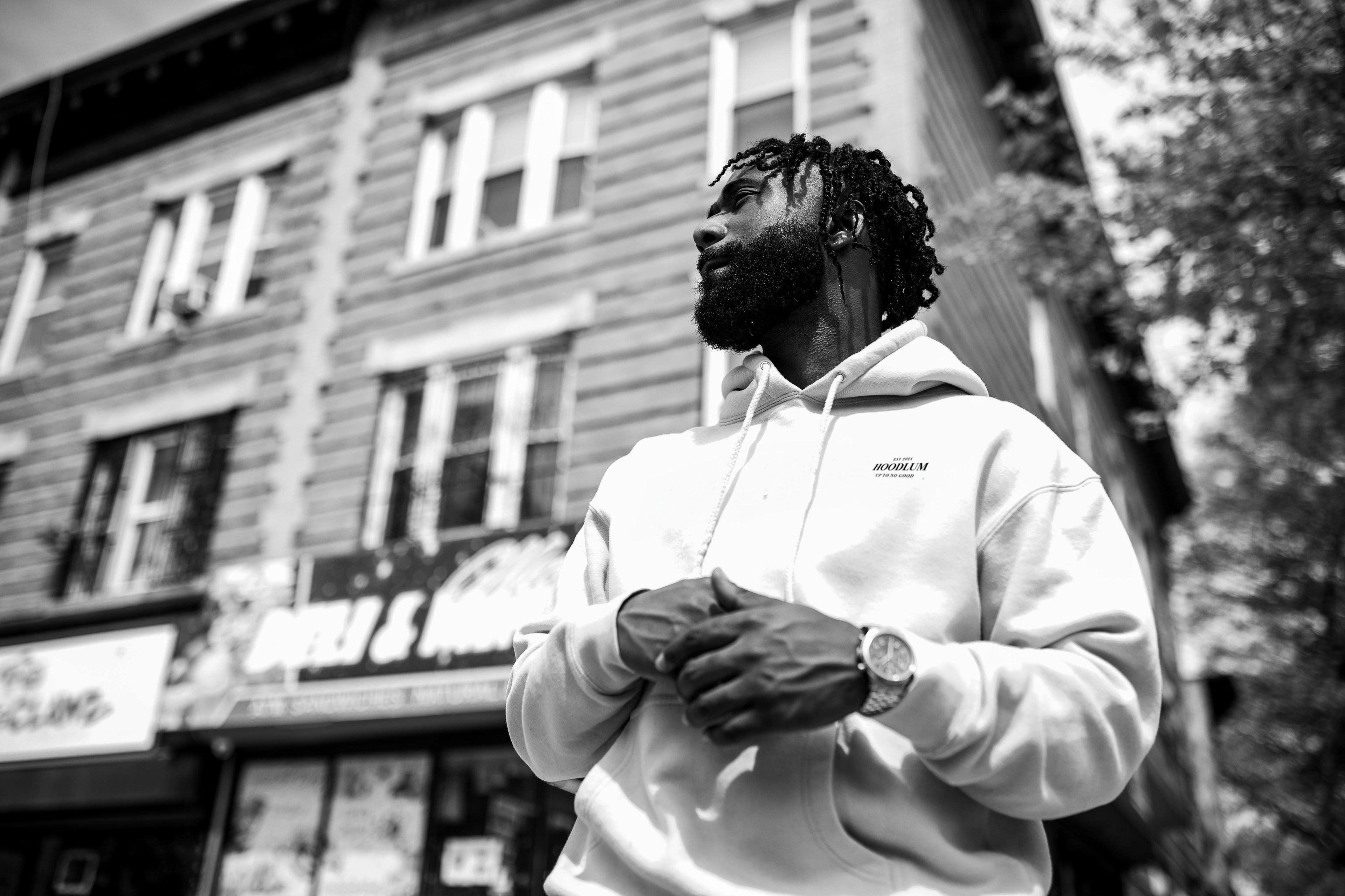 A Bearded Man in a Hoodie Standing near a Building in a City